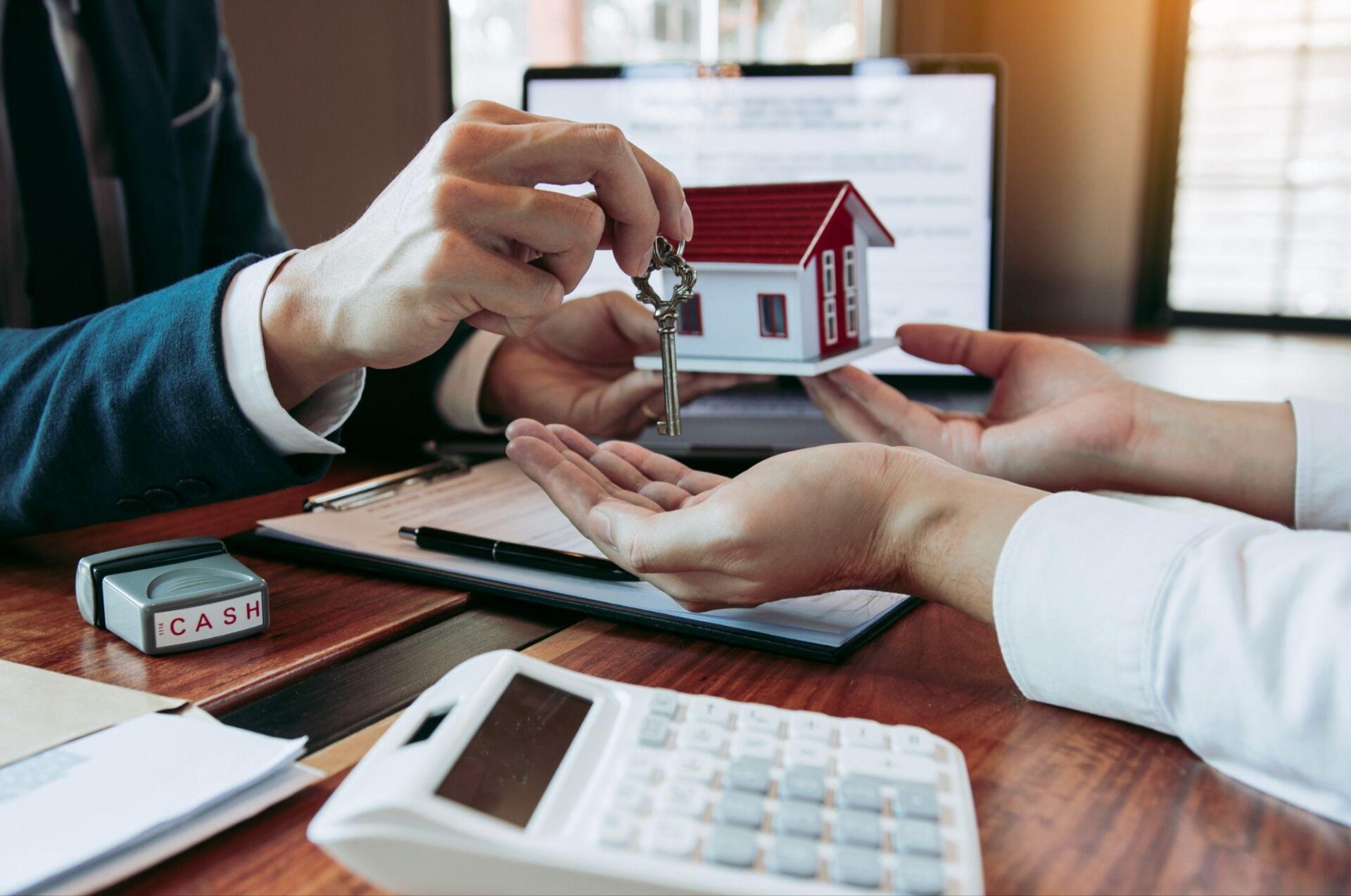 real estate person giving home key to the home buyer